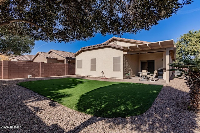 back of property with a patio and a yard