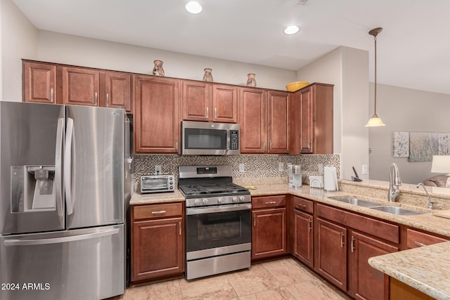 kitchen with appliances with stainless steel finishes, hanging light fixtures, light stone countertops, sink, and backsplash