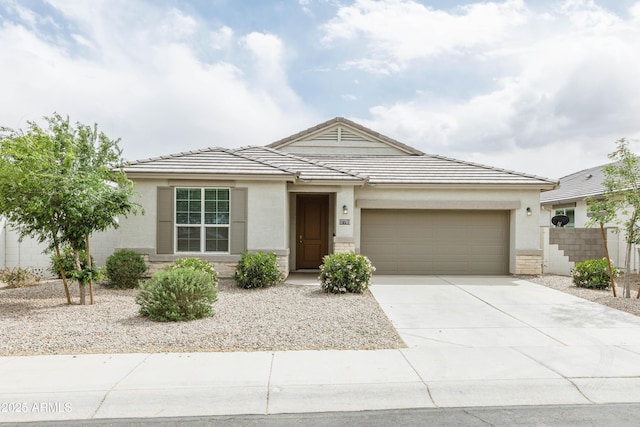 ranch-style home with fence, a garage, concrete driveway, a tile roof, and stucco siding