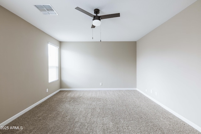 carpeted spare room with a ceiling fan, baseboards, and visible vents