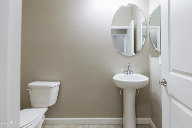 bathroom featuring toilet and baseboards