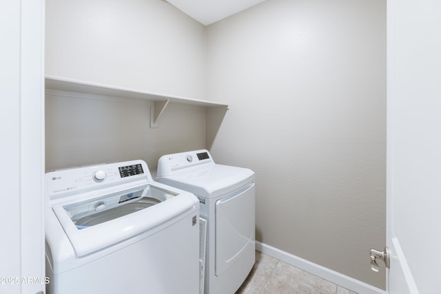 clothes washing area with washer and clothes dryer, laundry area, baseboards, and light tile patterned floors