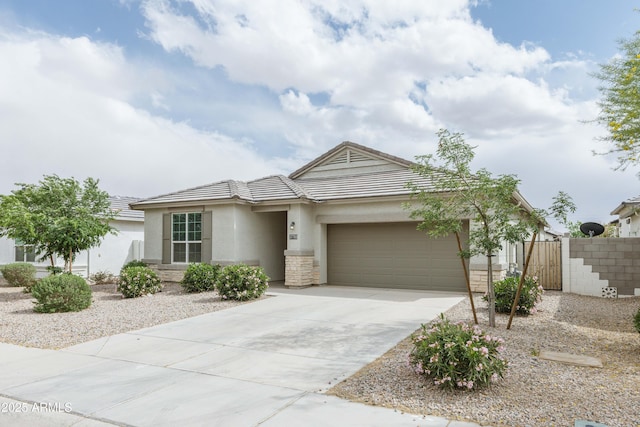 view of front of property featuring fence, an attached garage, stucco siding, a tile roof, and driveway