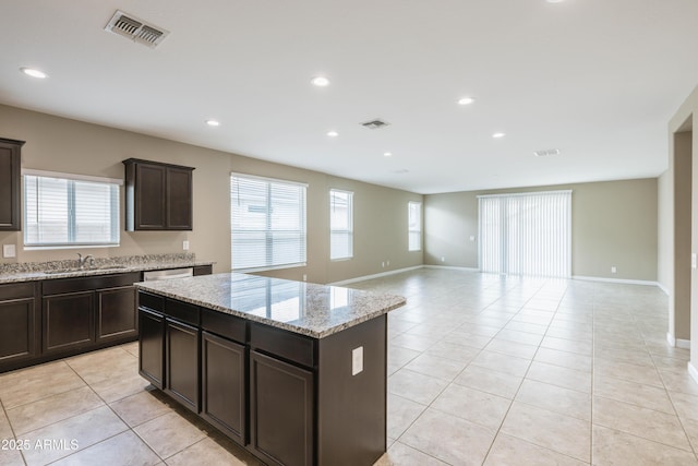 kitchen with open floor plan, light tile patterned floors, a sink, and visible vents