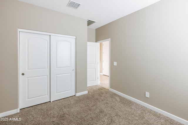 unfurnished bedroom with carpet flooring, baseboards, a closet, and visible vents