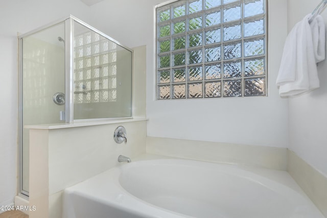 bathroom with a stall shower and a bath