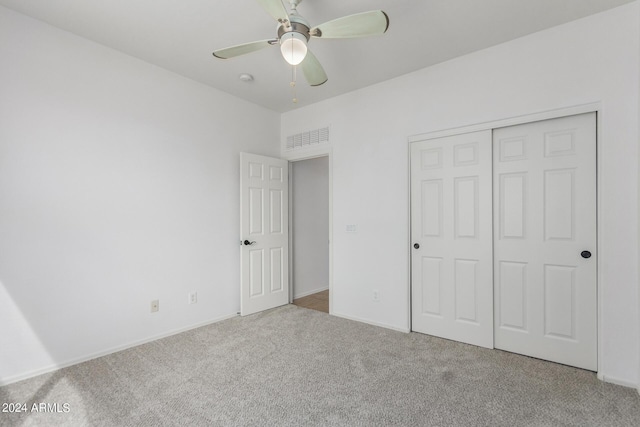 unfurnished bedroom featuring carpet floors, a closet, visible vents, and ceiling fan