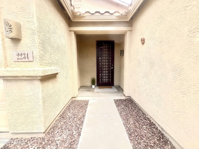 doorway to property featuring a tile roof and stucco siding