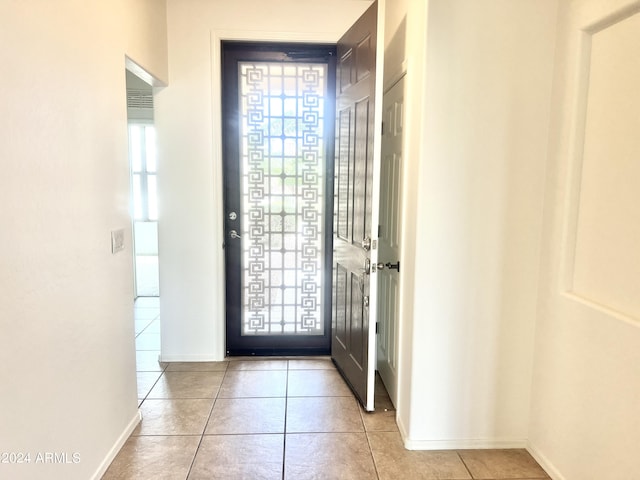 foyer featuring light tile patterned floors and baseboards