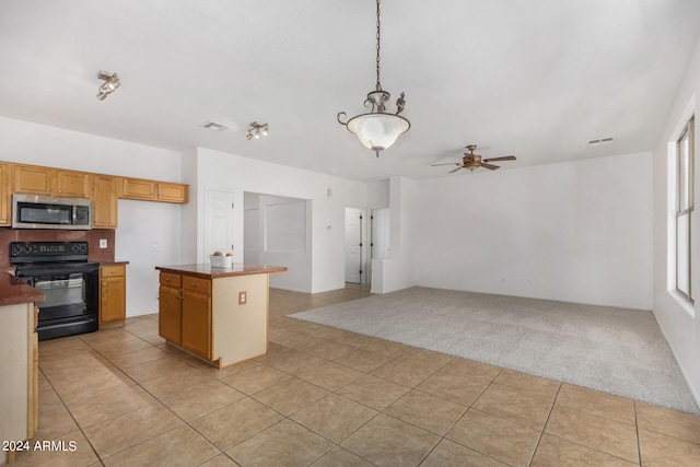 kitchen featuring hanging light fixtures, light colored carpet, black electric range oven, ceiling fan, and a kitchen island