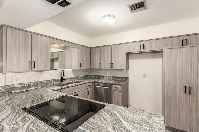 kitchen featuring a sink, dishwasher, stovetop with downdraft, dark stone countertops, and backsplash