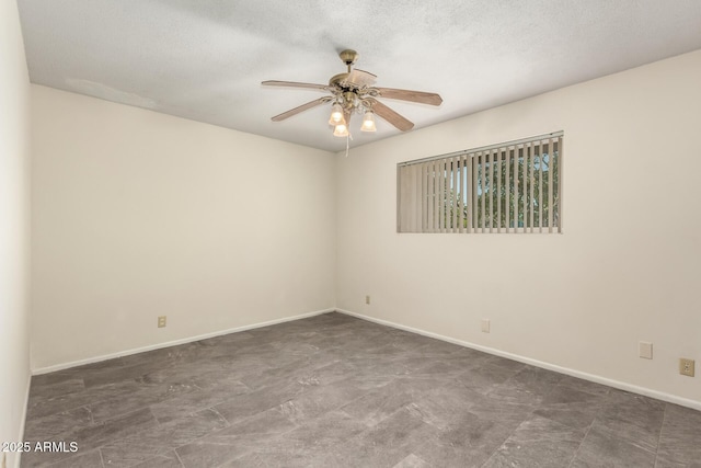 spare room with ceiling fan, baseboards, and a textured ceiling