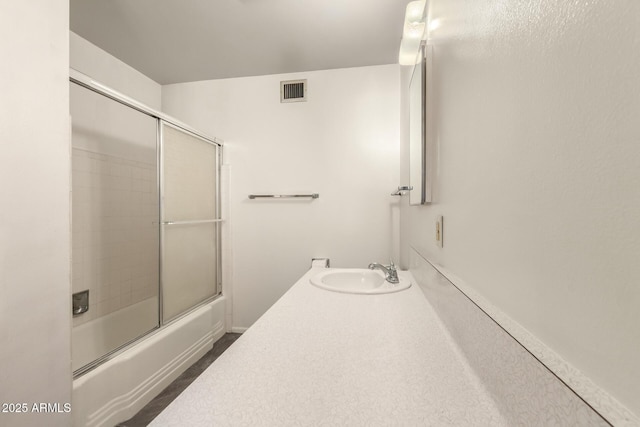 full bathroom featuring shower / bath combination with glass door and vanity