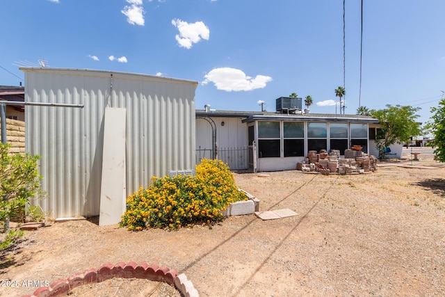 rear view of property with central AC unit and a patio area