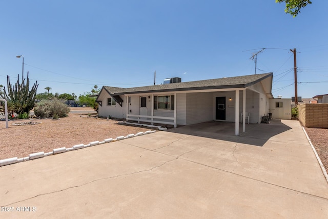 view of front of property featuring driveway, an attached carport, and fence