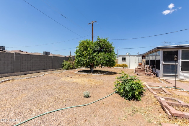 view of yard featuring fence and a sunroom
