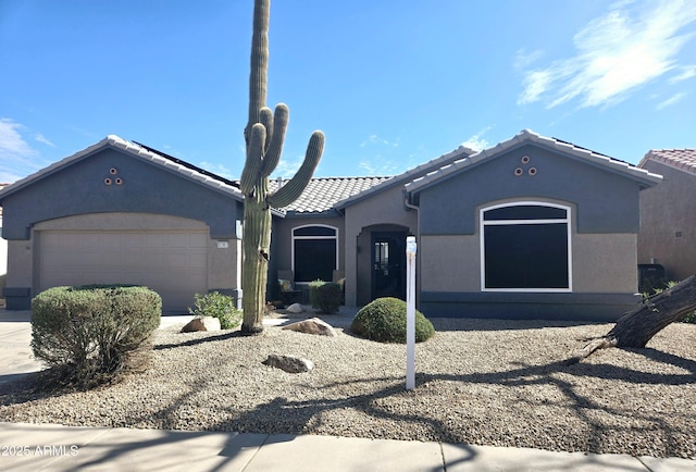 view of front of property featuring a garage, a tile roof, and stucco siding