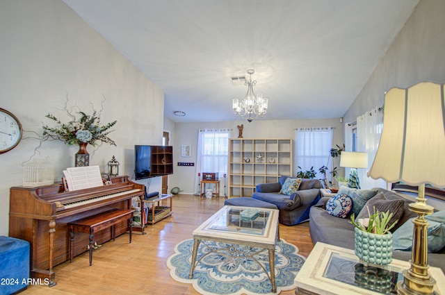 living room with lofted ceiling, light wood-type flooring, and a chandelier