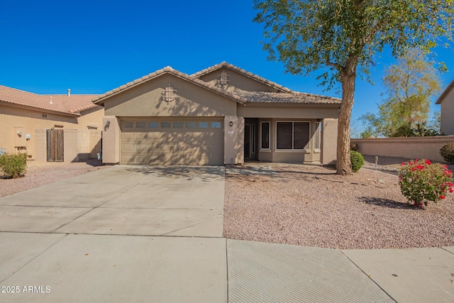 view of front of home featuring an attached garage, fence, concrete driveway, and stucco siding