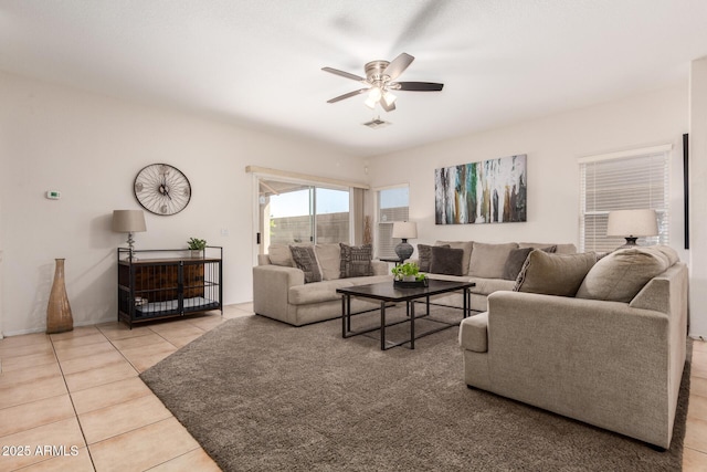 living area with a ceiling fan and tile patterned floors