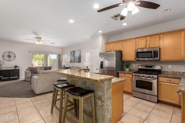 kitchen with light tile patterned floors, visible vents, stainless steel appliances, and backsplash