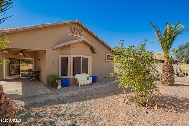 back of house with a ceiling fan, a patio, a tiled roof, fence, and stucco siding