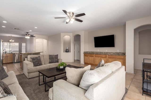 living room with arched walkways, ceiling fan, light tile patterned flooring, recessed lighting, and visible vents