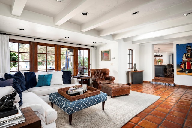 living room featuring tile patterned flooring, beam ceiling, a chandelier, and a healthy amount of sunlight