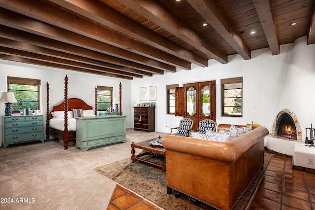 bedroom with beam ceiling, light carpet, a brick fireplace, and wooden ceiling