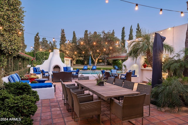 patio terrace at dusk with exterior fireplace