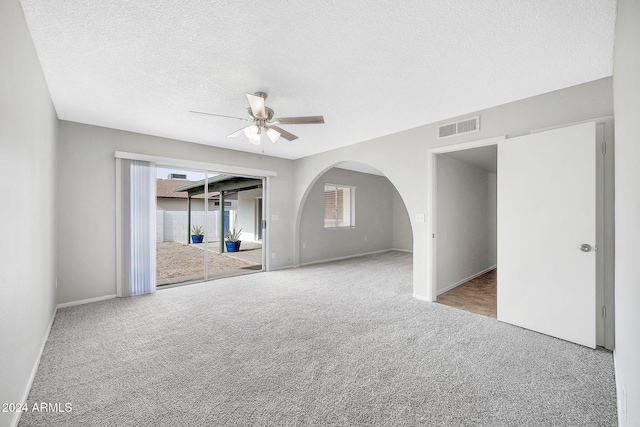 carpeted spare room with a textured ceiling and ceiling fan