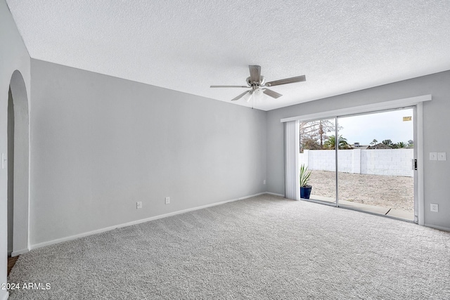 carpeted empty room featuring ceiling fan and a textured ceiling