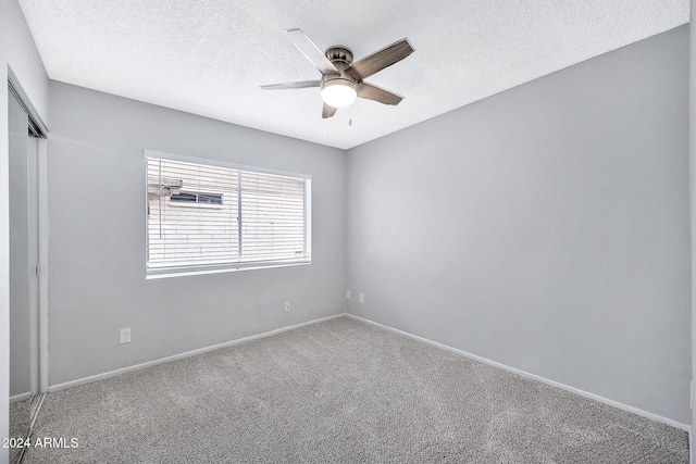 empty room with carpet, ceiling fan, and a textured ceiling