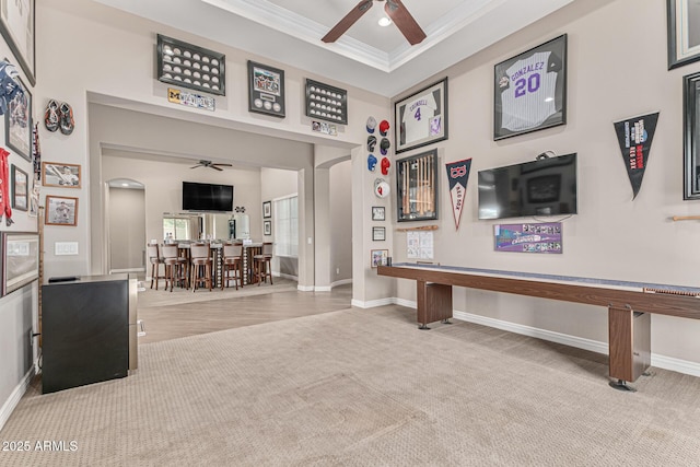 recreation room featuring ceiling fan, crown molding, and carpet floors