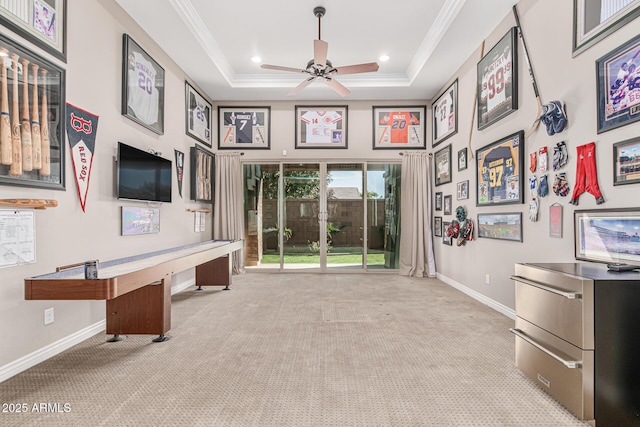 playroom with a tray ceiling, ceiling fan, crown molding, and light colored carpet