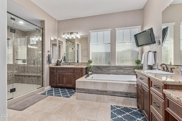 bathroom featuring tile patterned floors, vanity, and shower with separate bathtub