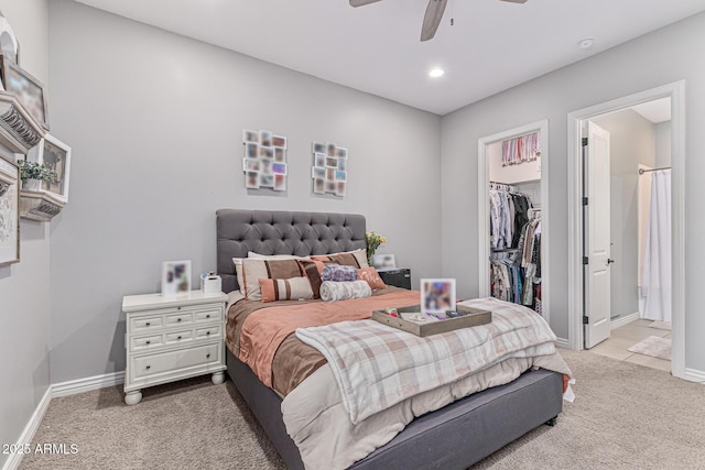 bedroom featuring ensuite bath, light colored carpet, ceiling fan, a spacious closet, and a closet