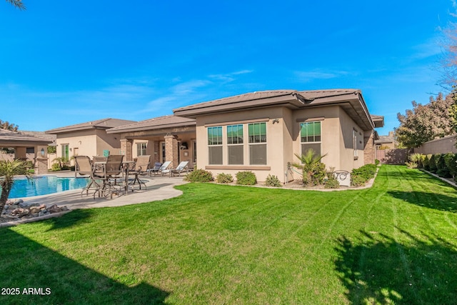 rear view of property with a yard and a patio area