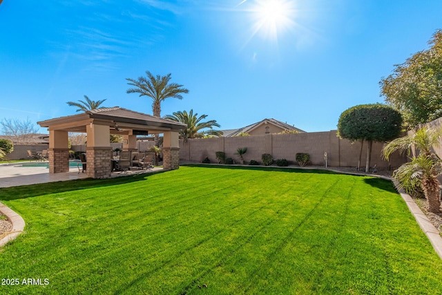 view of yard featuring ceiling fan, a patio area, and a fenced in pool