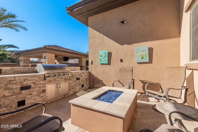 view of patio featuring a gazebo, area for grilling, and a fire pit