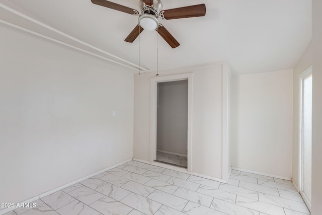 empty room with baseboards, marble finish floor, and a ceiling fan