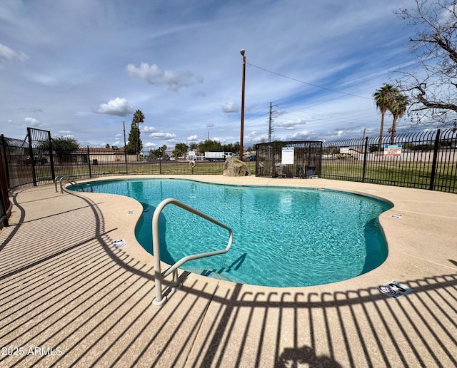 pool with a patio and fence