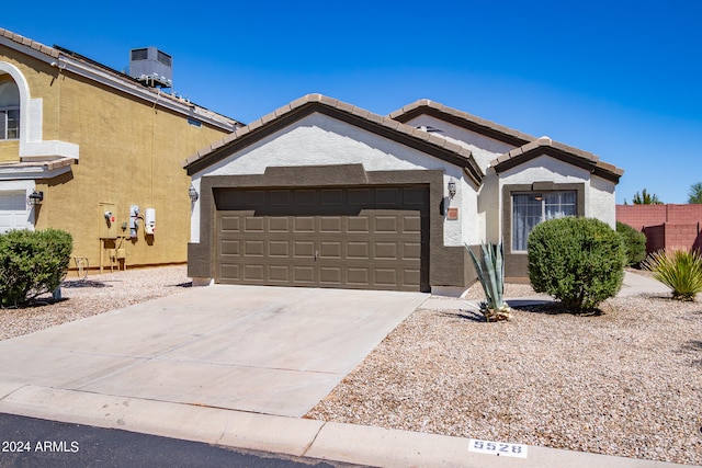 view of front of house featuring a garage and central AC