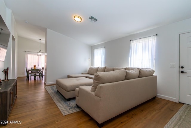 living room featuring vaulted ceiling, plenty of natural light, and hardwood / wood-style flooring