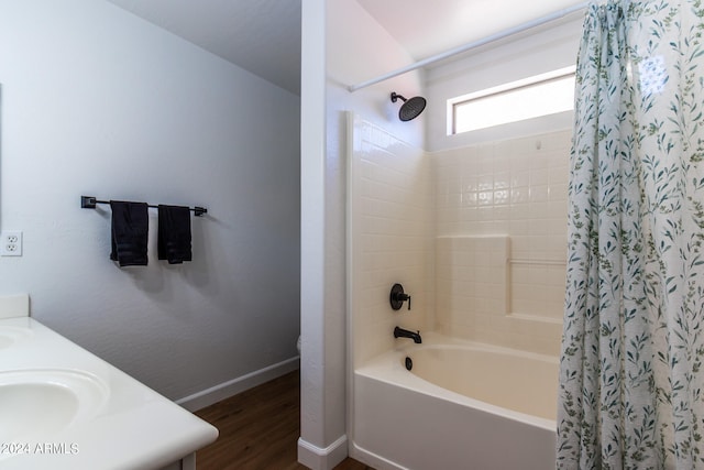 bathroom with hardwood / wood-style flooring, shower / tub combo, and sink