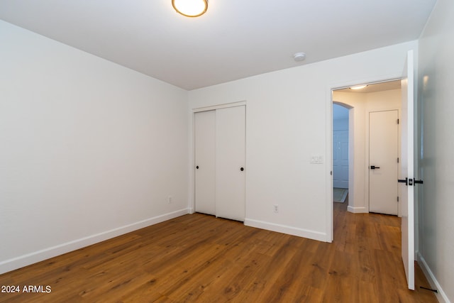 unfurnished bedroom with a closet and hardwood / wood-style floors