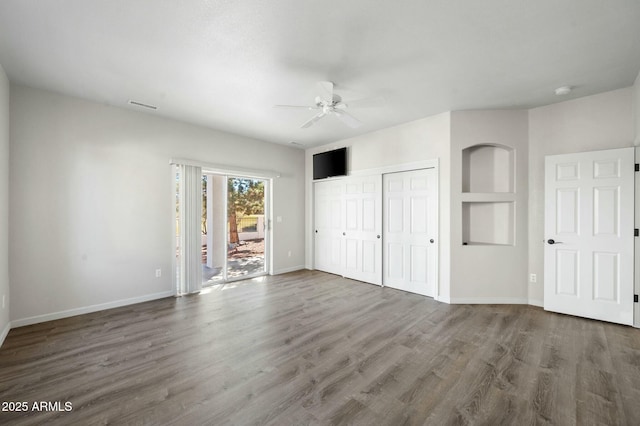 unfurnished bedroom featuring ceiling fan, dark hardwood / wood-style flooring, and access to outside