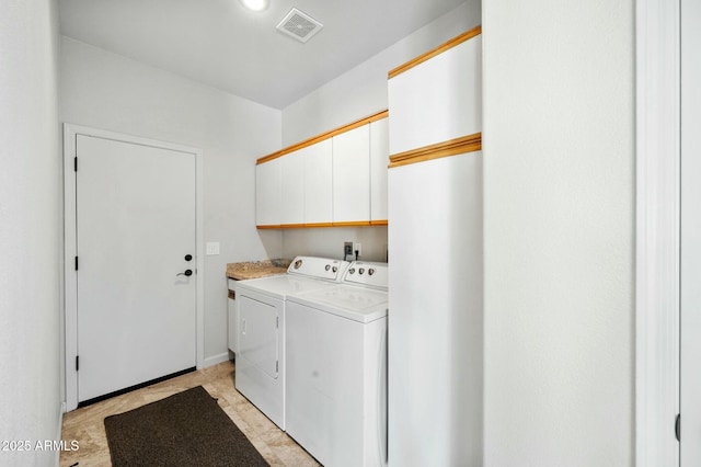 washroom with cabinets and washing machine and dryer