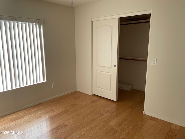 unfurnished bedroom featuring light wood-type flooring and a closet