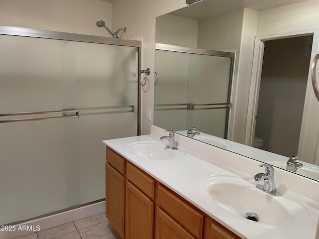 bathroom with tile patterned flooring, vanity, toilet, and a shower with door